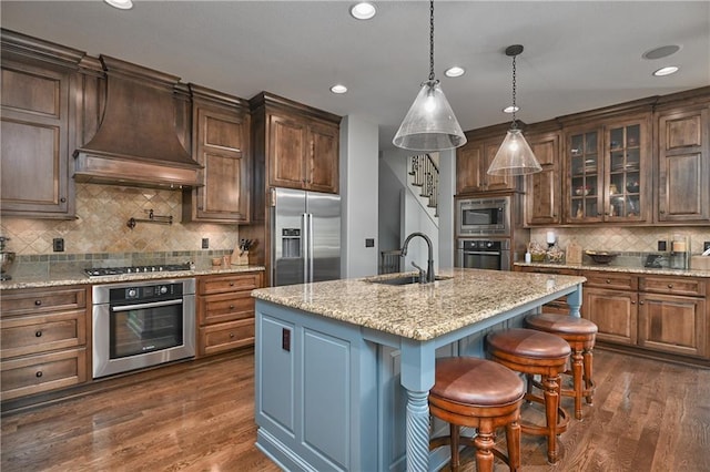 4502 Verona Ct, Riverside, MO 64150 - kitchen with appliances with stainless steel finishes, a sink, premium range hood, decorative backsplash, and recessed lighting