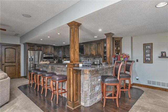 4502 Verona Ct, Riverside, MO 64150 - indoor wet bar with ornate columns, baseboards, appliances with stainless steel finishes, a textured ceiling, and recessed lighting