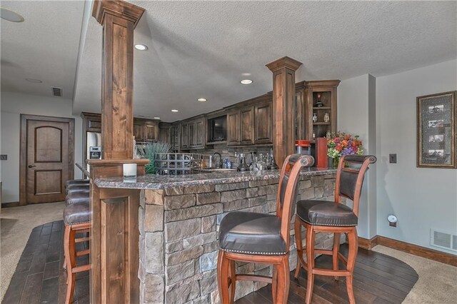 4502 Verona Ct, Riverside, MO 64150 - indoor bar featuring decorative columns, carpet, baseboards, recessed lighting, and a textured ceiling