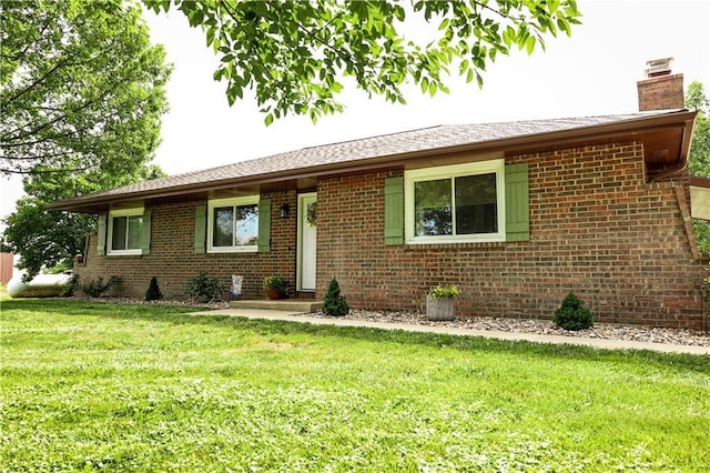 single story home with a chimney, brick siding, and a front lawn