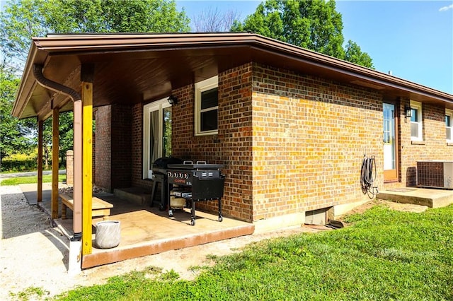 view of side of property with brick siding and cooling unit