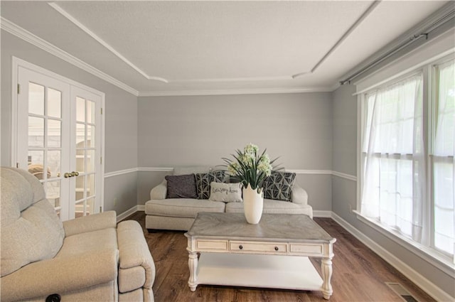 living room with dark wood-style floors, plenty of natural light, baseboards, ornamental molding, and french doors