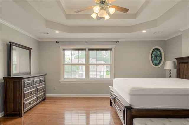 bedroom with a raised ceiling, light wood-style floors, baseboards, recessed lighting, and crown molding