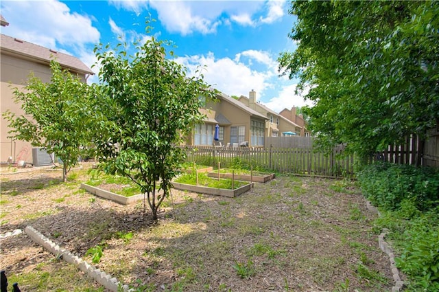 view of yard featuring a garden, fence, and central air condition unit