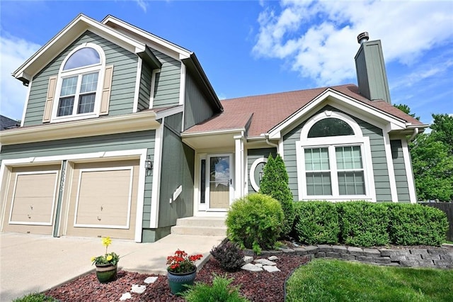 15363 S Darnell St, Olathe, KS 66062 - view of front of house featuring a garage, concrete driveway, and a chimney