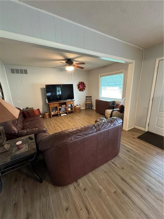 209 S 4th St, Arma, KS 66712 - living room featuring wood finished floors, ceiling fan, a textured ceiling, and baseboards