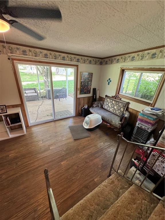 209 S 4th St, Arma, KS 66712 - living area with hardwood / wood-style floors, a ceiling fan, and a textured ceiling