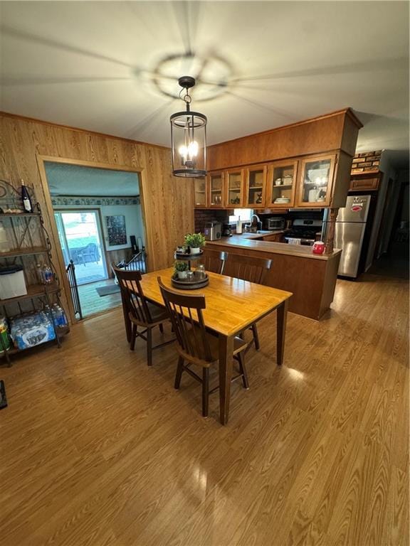 209 S 4th St, Arma, KS 66712 - dining area featuring wooden walls and light wood-type flooring