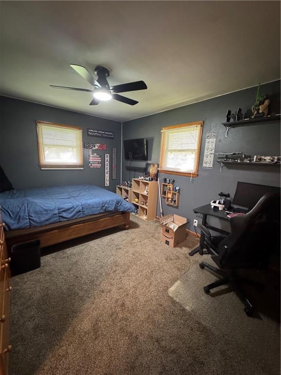 209 S 4th St, Arma, KS 66712 - carpeted bedroom with an office area, a ceiling fan, and baseboards