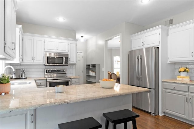 5318 W 159th Ter, Overland Park, KS 66085 - kitchen with stainless steel appliances, a sink, backsplash, a peninsula, and white cabinetry