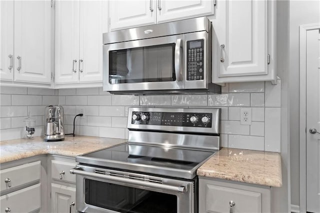 5318 W 159th Ter, Overland Park, KS 66085 - kitchen with stainless steel appliances, white cabinetry, and decorative backsplash