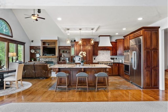 8127 Lone Elm Rd, Lenexa, KS 66220 - kitchen featuring appliances with stainless steel finishes, premium range hood, open floor plan, a kitchen breakfast bar, and ceiling fan