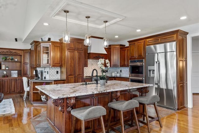 8127 Lone Elm Rd, Lenexa, KS 66220 - kitchen with stainless steel appliances, light wood-style floors, an island with sink, light stone counters, and recessed lighting