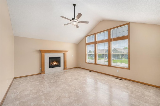 unfurnished living room with a ceiling fan, a fireplace, lofted ceiling, baseboards, and tile patterned floors