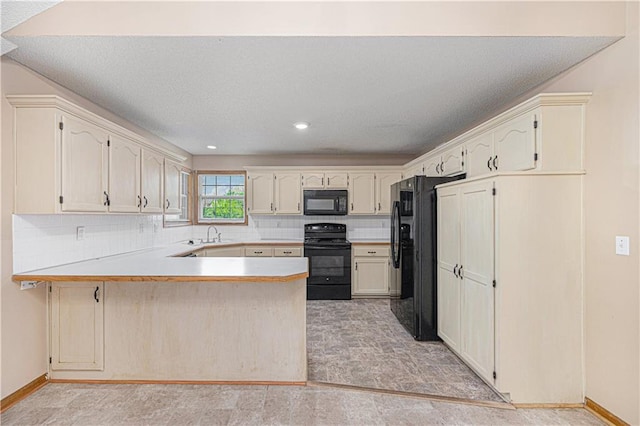 kitchen with black appliances, a peninsula, light countertops, tasteful backsplash, and a sink