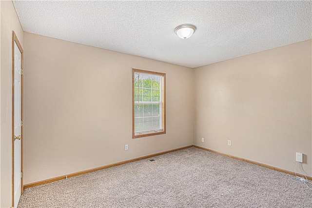 unfurnished room with carpet, a textured ceiling, and baseboards