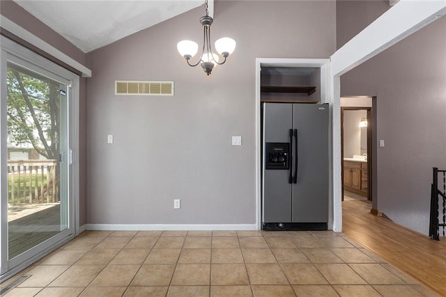 4010 Hedges Ave, Kansas City, MO 64133 - kitchen featuring stainless steel refrigerator with ice dispenser, lofted ceiling, a chandelier, baseboards, and light tile patterned flooring