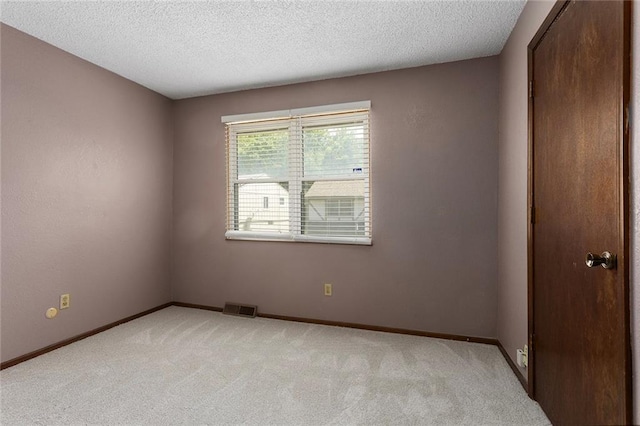 4010 Hedges Ave, Kansas City, MO 64133 - unfurnished room with light colored carpet, baseboards, and a textured ceiling
