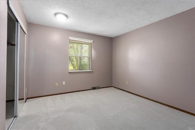 4010 Hedges Ave, Kansas City, MO 64133 - unfurnished bedroom featuring carpet flooring, baseboards, and a textured ceiling