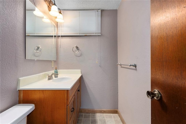 4010 Hedges Ave, Kansas City, MO 64133 - bathroom featuring toilet, vanity, baseboards, and a textured wall