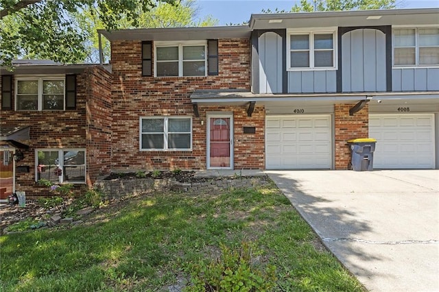 4010 Hedges Ave, Kansas City, MO 64133 - view of property featuring brick siding, driveway, a garage, and board and batten siding
