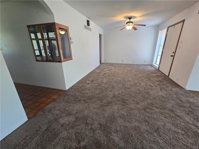 33295 Bethel Church Rd, Osawatomie, KS 66064 - carpeted empty room with a ceiling fan, arched walkways, and tile patterned floors