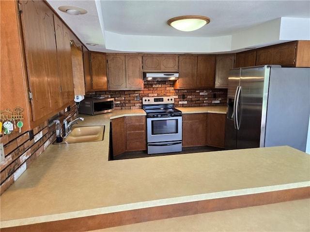33295 Bethel Church Rd, Osawatomie, KS 66064 - kitchen with appliances with stainless steel finishes, under cabinet range hood, a sink, and backsplash