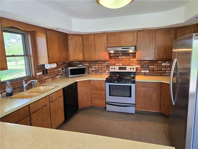 33295 Bethel Church Rd, Osawatomie, KS 66064 - kitchen with appliances with stainless steel finishes, under cabinet range hood, a sink, light countertops, and tasteful backsplash