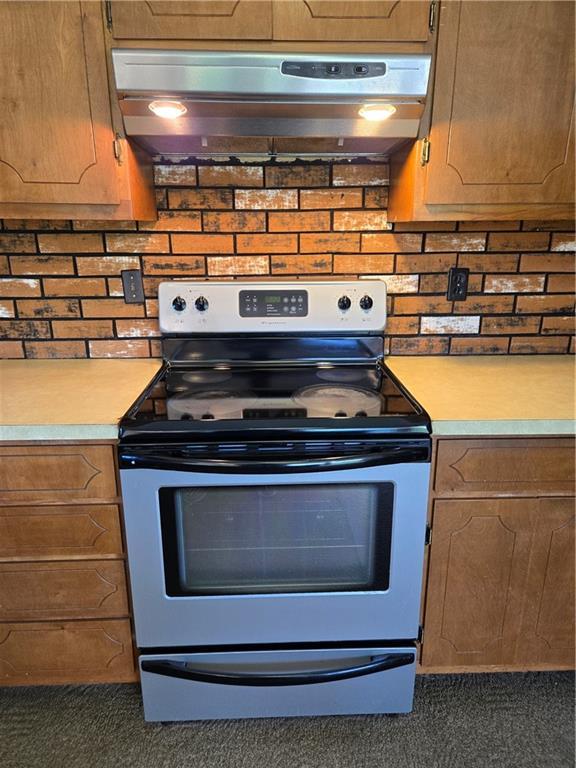 33295 Bethel Church Rd, Osawatomie, KS 66064 - kitchen featuring electric stove, under cabinet range hood, light countertops, and carpet flooring