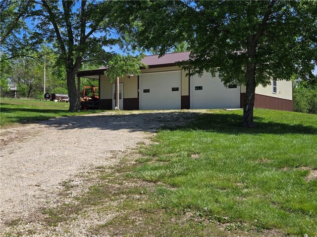 33295 Bethel Church Rd, Osawatomie, KS 66064 - view of home's exterior with a lawn, a garage, metal roof, and driveway
