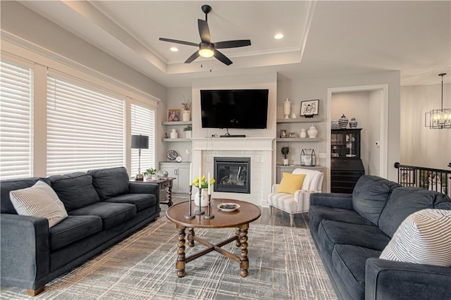 11410 Bluestem Dr, Kearney, MO 64060 - living area featuring ceiling fan, a raised ceiling, a chandelier, a tiled fireplace, and recessed lighting
