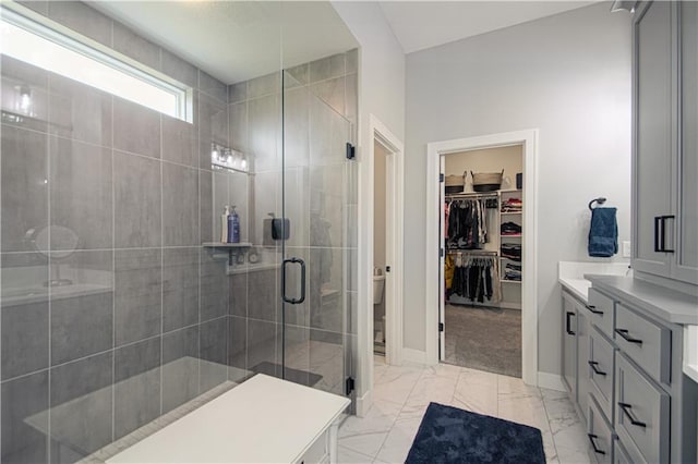 11410 Bluestem Dr, Kearney, MO 64060 - full bath featuring a shower stall, vanity, a spacious closet, baseboards, and marble look tiles