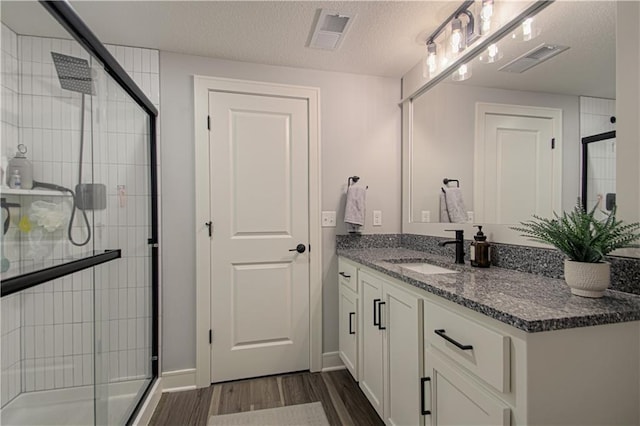 11410 Bluestem Dr, Kearney, MO 64060 - full bathroom featuring a stall shower, wood finished floors, vanity, and a textured ceiling