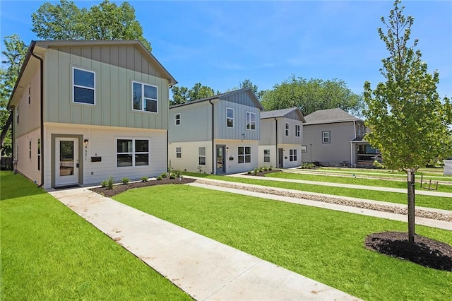 view of front facade featuring board and batten siding, a front yard, and a residential view