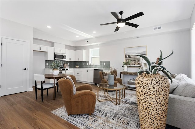 living area with wood finished floors, a ceiling fan, and recessed lighting