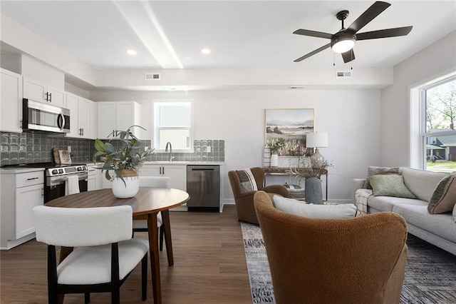 living room featuring a ceiling fan, dark wood-style flooring, and recessed lighting