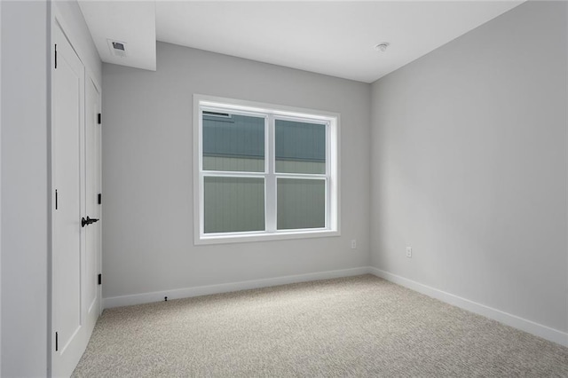 unfurnished room with carpet flooring and baseboards