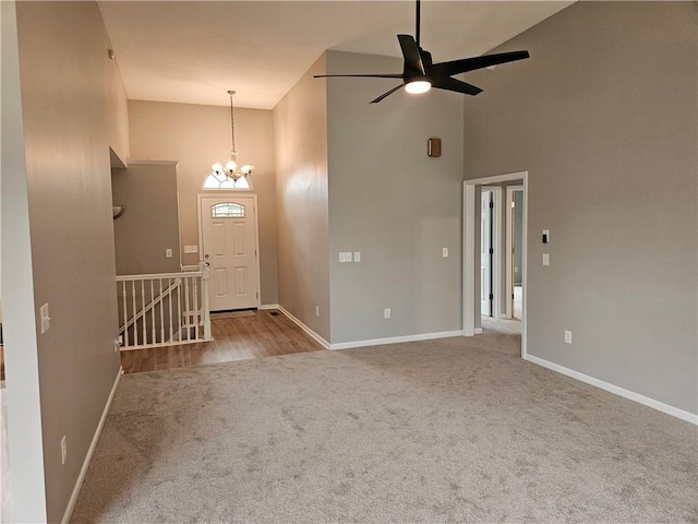 1309 Thomas Dr, Louisburg, KS 66053 - carpeted foyer with high vaulted ceiling, a ceiling fan, baseboards, and a chandelier