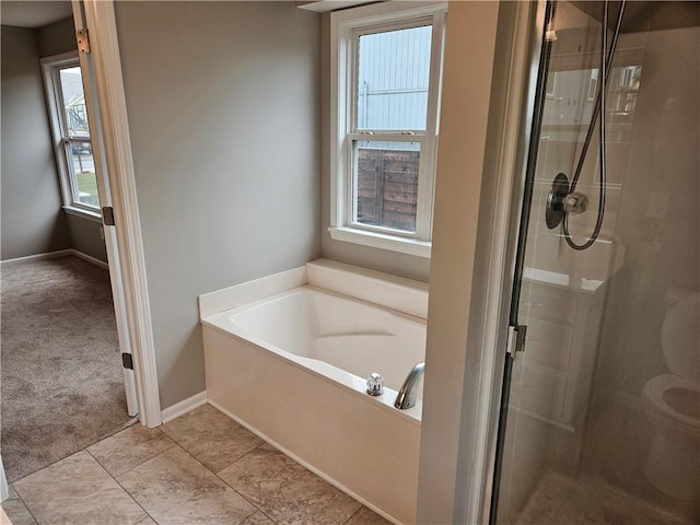 1309 Thomas Dr, Louisburg, KS 66053 - bathroom featuring a shower stall, a garden tub, toilet, and baseboards