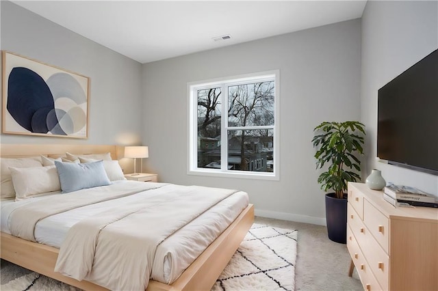 bedroom with light colored carpet and baseboards