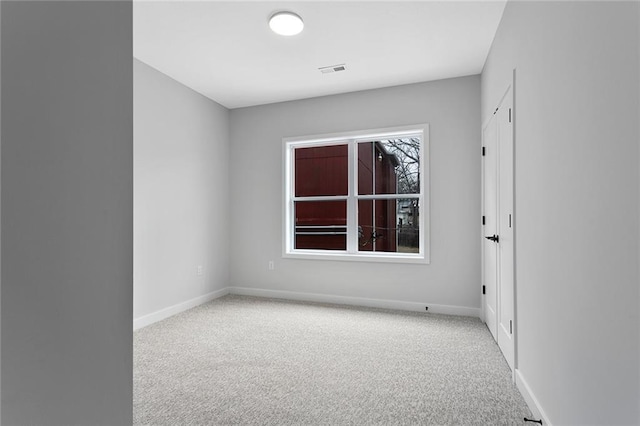 carpeted spare room featuring baseboards