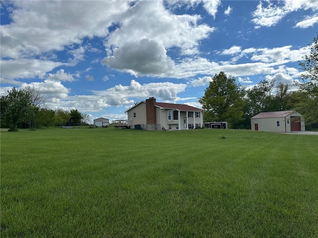 view of green lawn featuring an outdoor structure and a garage