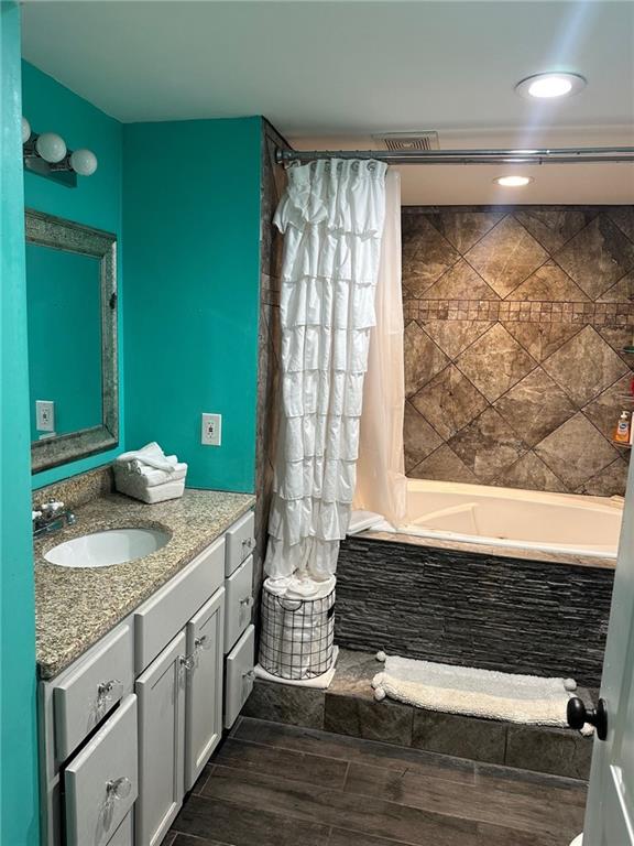 bathroom with vanity, wood finished floors, shower / tub combo with curtain, and recessed lighting