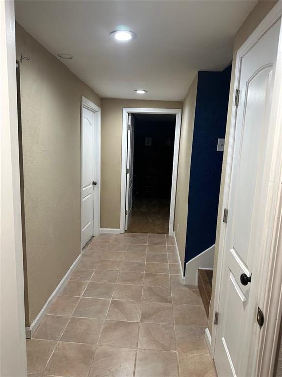 hallway with recessed lighting, baseboards, and light tile patterned flooring