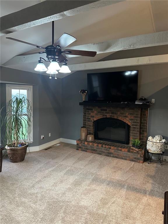 carpeted living room featuring ceiling fan, a brick fireplace, and baseboards