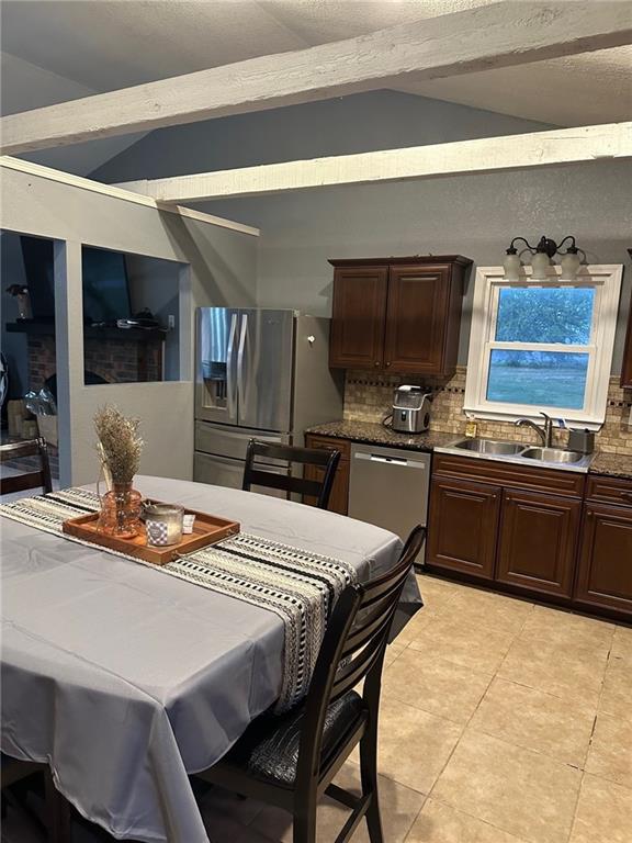 dining area featuring lofted ceiling and light tile patterned floors