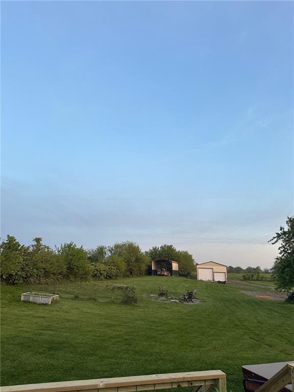 view of green lawn with an outbuilding and a garage