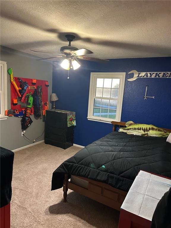 bedroom featuring carpet, a textured ceiling, and ceiling fan