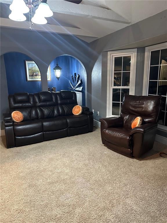 cinema room with carpet floors, vaulted ceiling, baseboards, and a chandelier