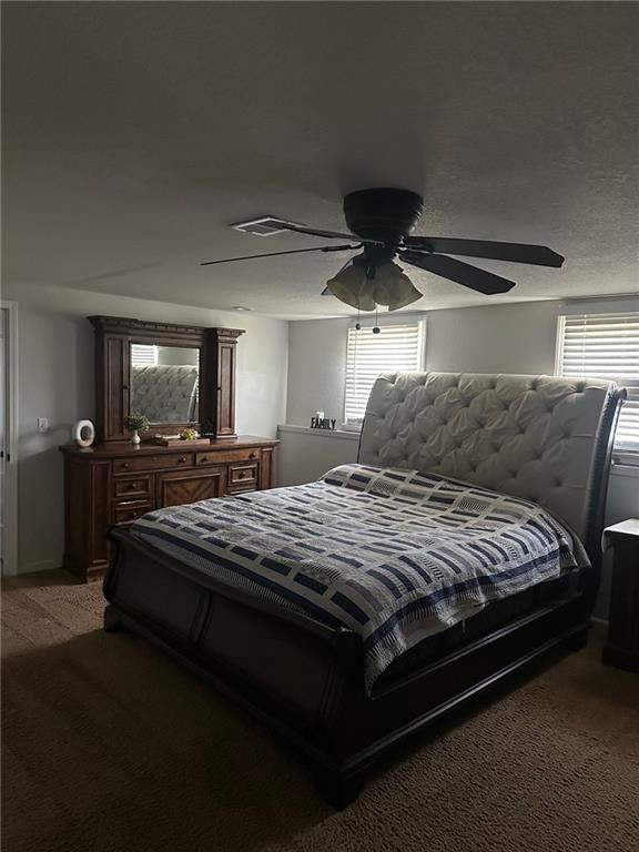 bedroom featuring multiple windows, light carpet, and a ceiling fan